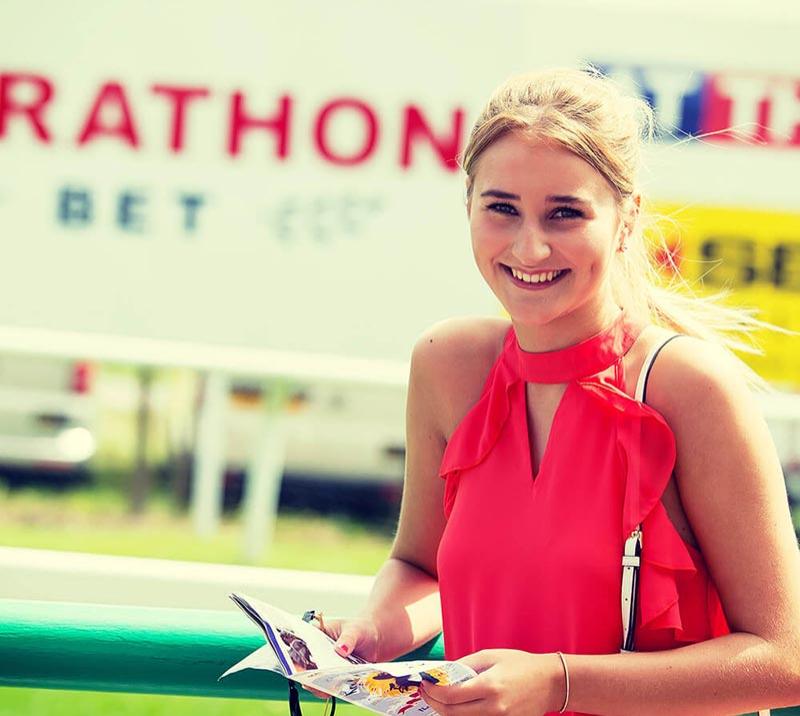 A lady looks through the race programme at Brighton Racecourse.