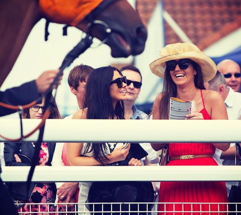 Smiling ladies attending races at Brighton Racecourse.