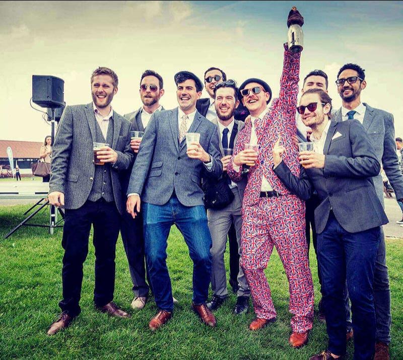 Group of dressed up gentlemen attending races at Brighton Racecourse.