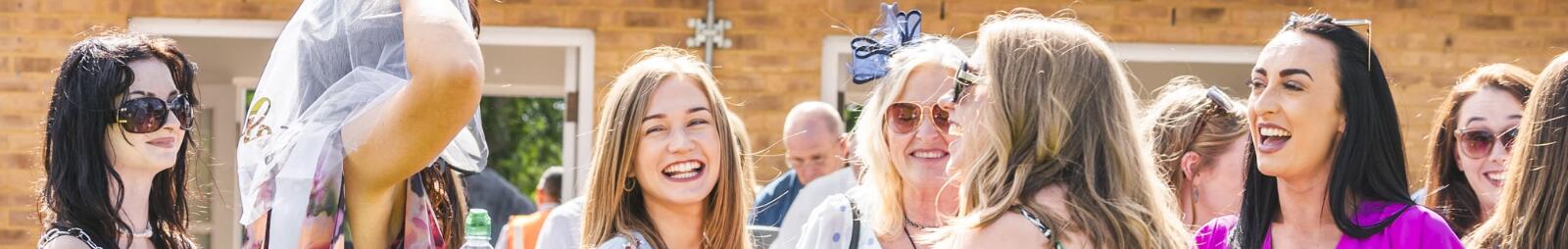 A bridal party laughing at the races