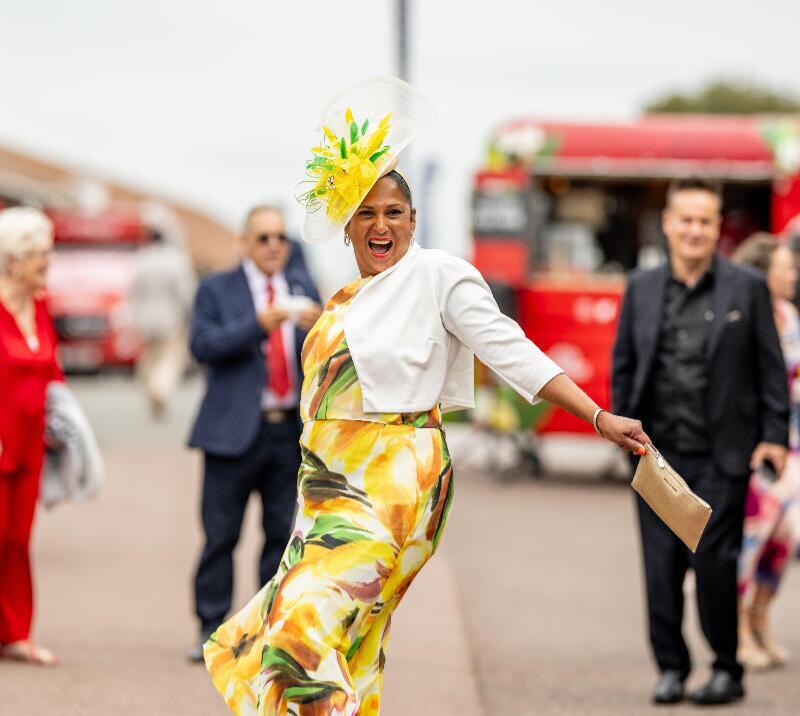 A race goer poses dramatically as she enters Brighton Races