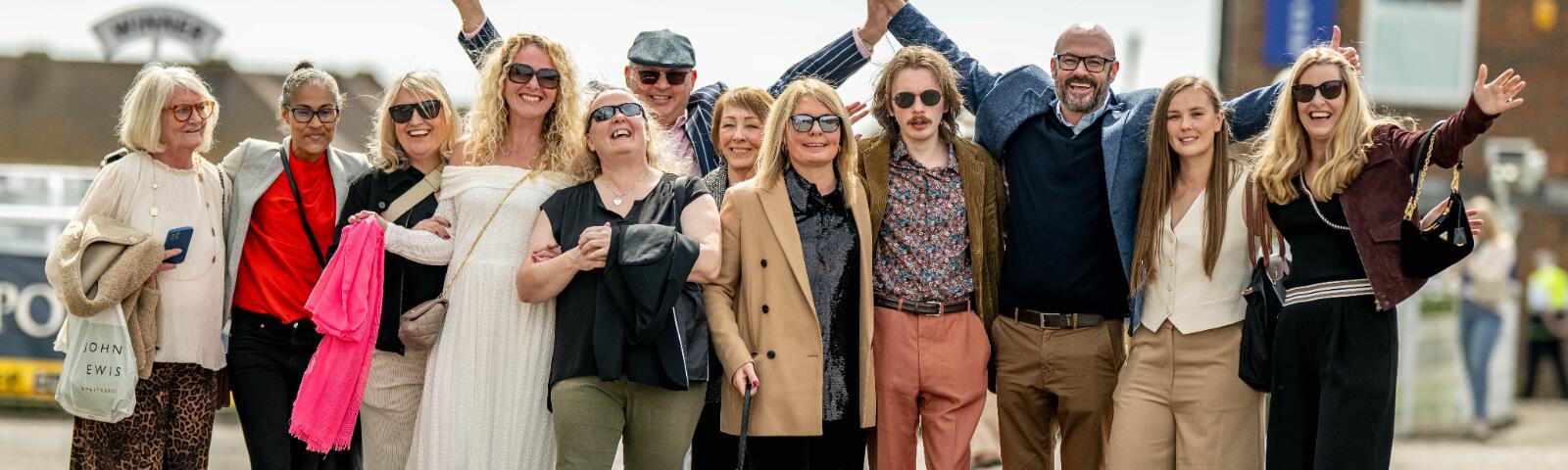 A large group of friends pose outside of Brighton Racecourse