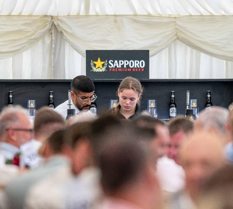 Two members of bar staff at Brighton Racecourse serve customers